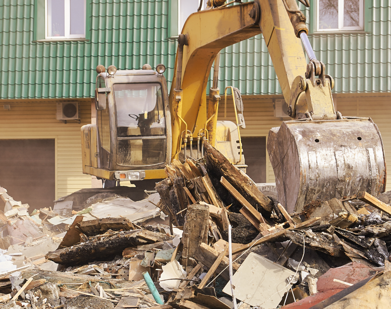Crew clearing debris from partially demolished residential structure before rebuild