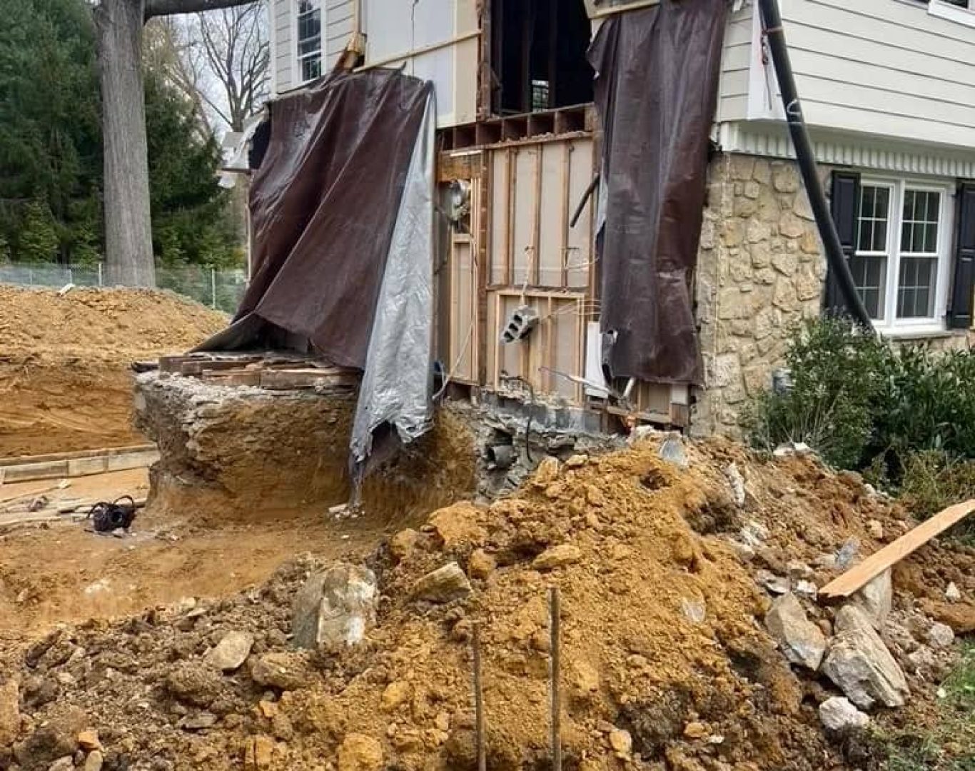 Demolition crew clearing damaged detached structure before residential rebuilding project begins