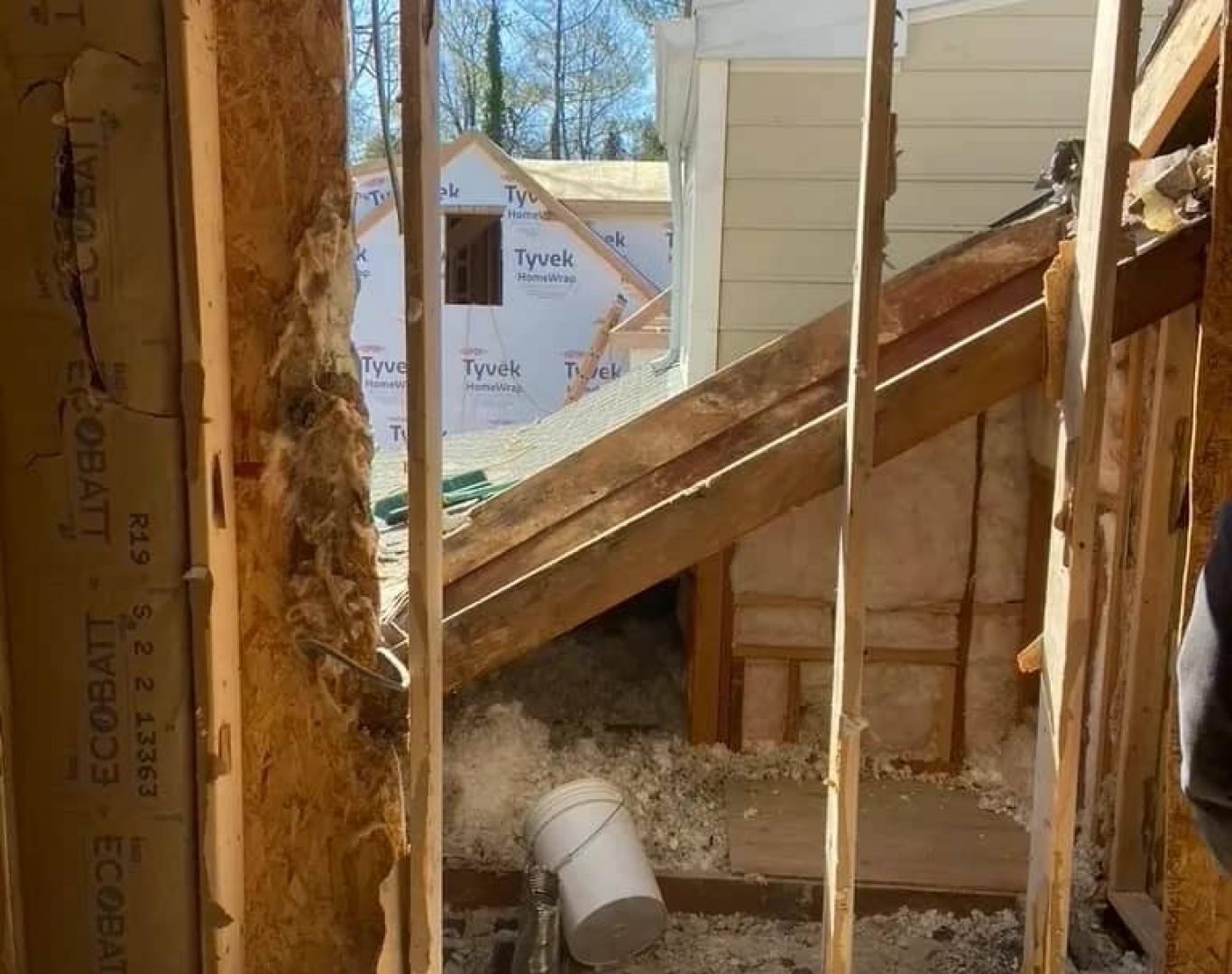 Demolition crew removing detached garage materials before residential rebuild begins